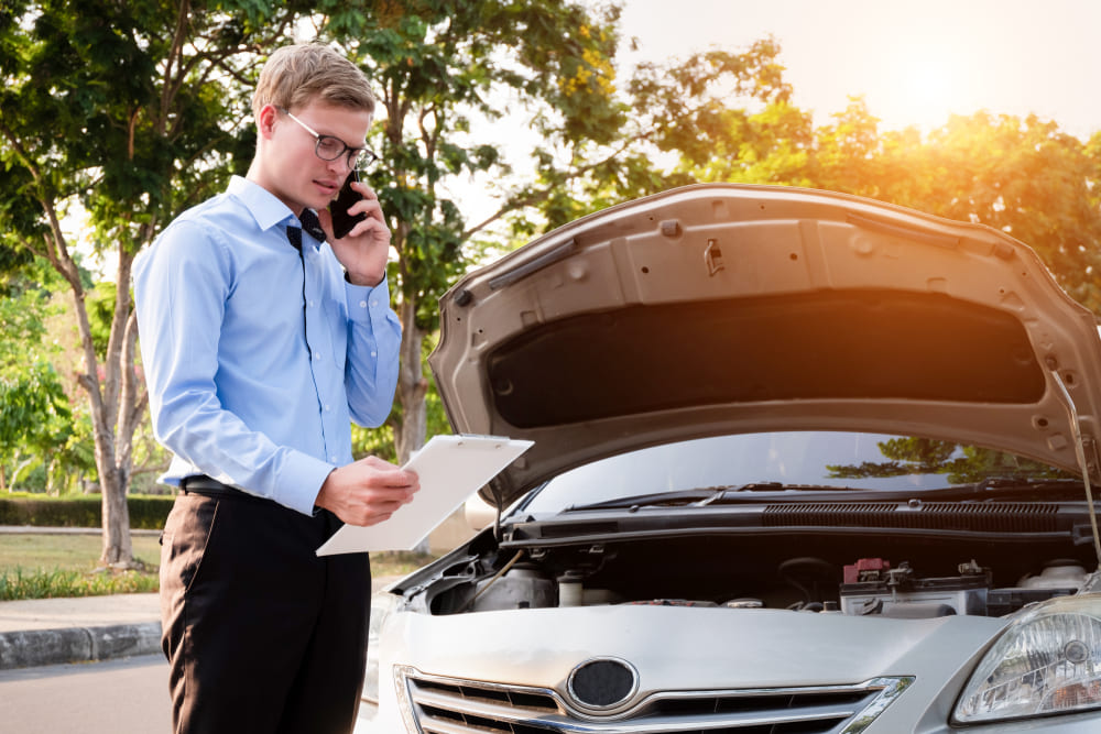 insurance agent inspecting car after an accident