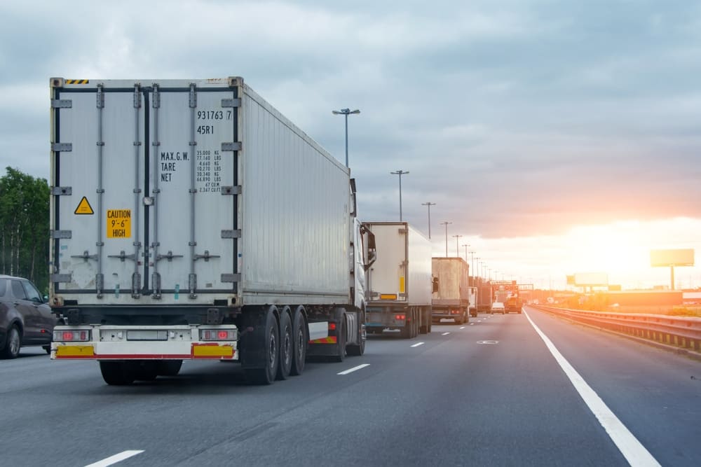 trucks on the road in traffic at sunset