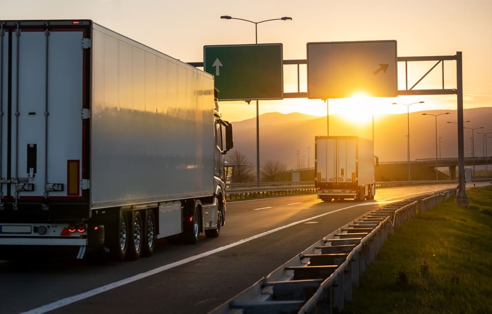 trucks driving at sunset