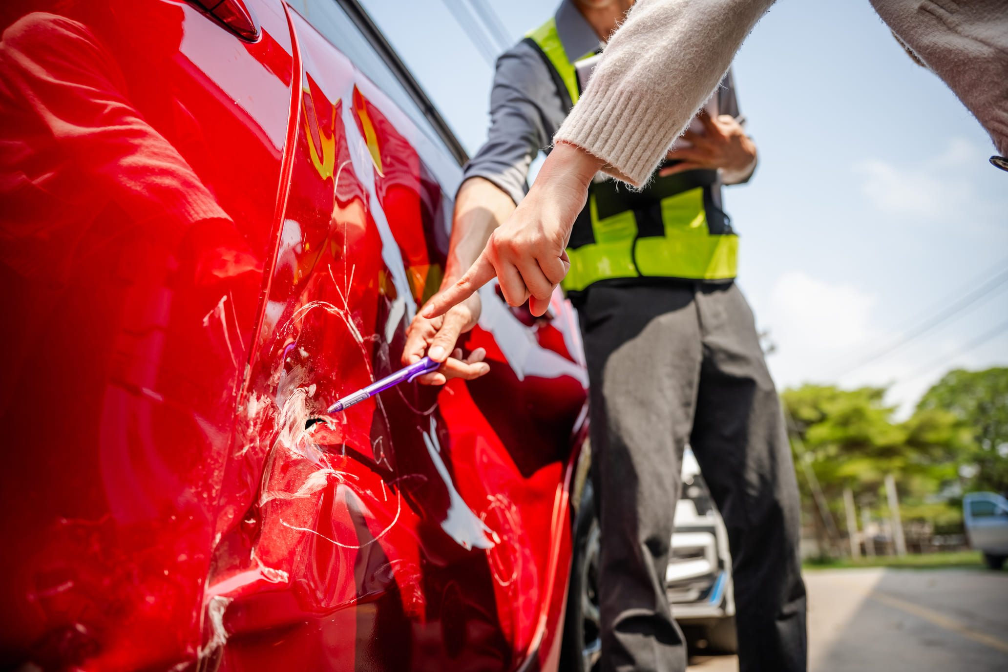 insurance rep assessing damage after car accident