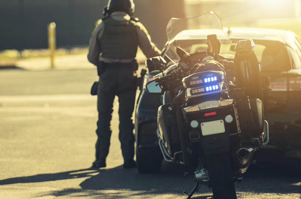 police officer on motorcycle giving traffic ticket to car driver in Texas