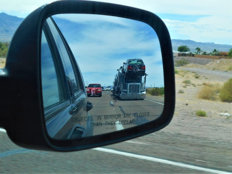 driver on Texas highway with truck in side mirror