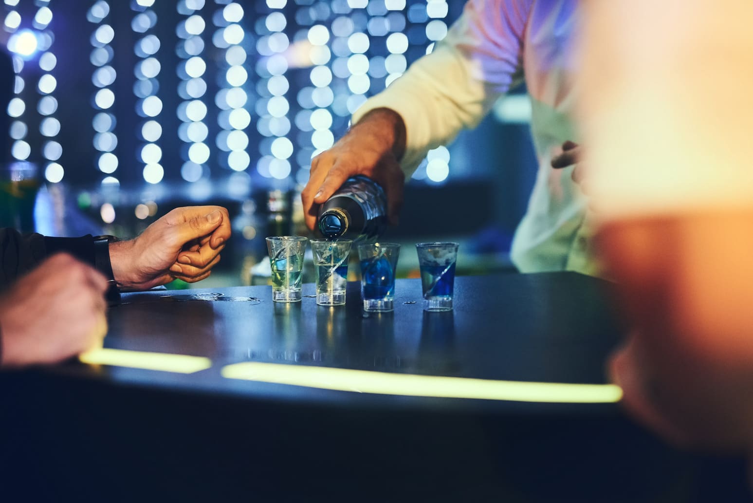 bartender pouring shots for patrons at a club