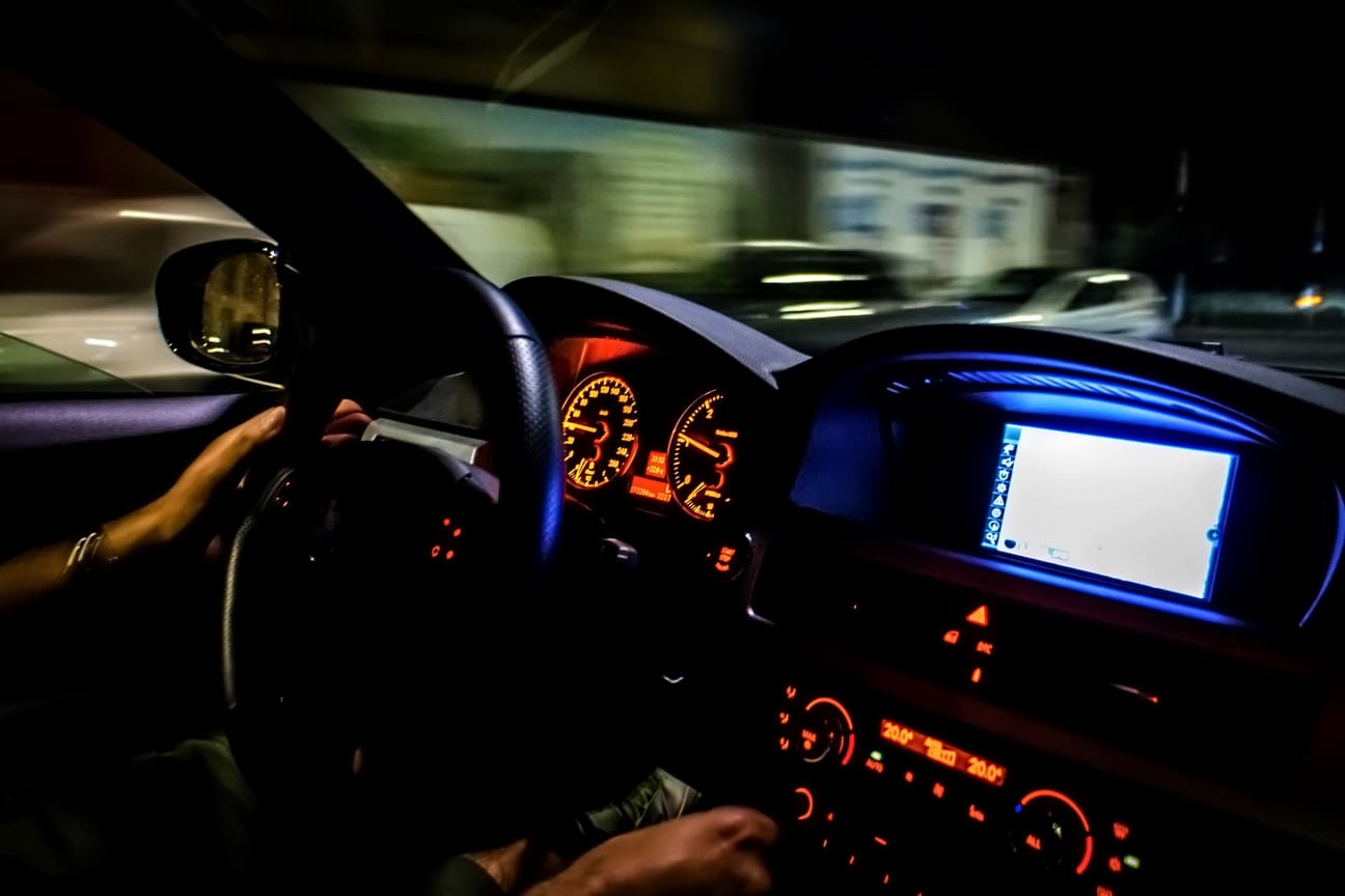 driver inside of car at night speeding